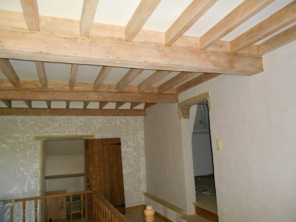 renovatie geriesturerd houten balken plafond en bezette muren